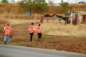 Imagen de dos voluntarios entrando en un asentamiento.
