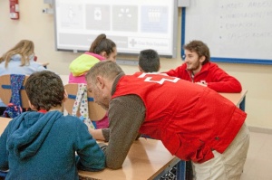 Voluntarios de Cruz Roja ayudando a algunos escolares.