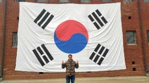 Nuestro viajero posa delante de la bandera de Corea del Sur, su casa durante este semestre.
