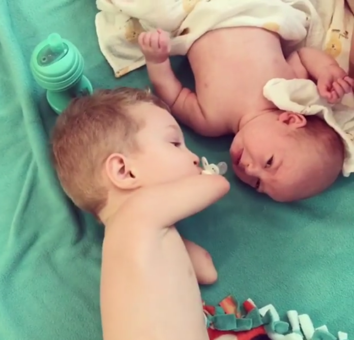 La tierna imagen de un bebé sin brazos poniendo el chupete a su hermano para tranquilizarle