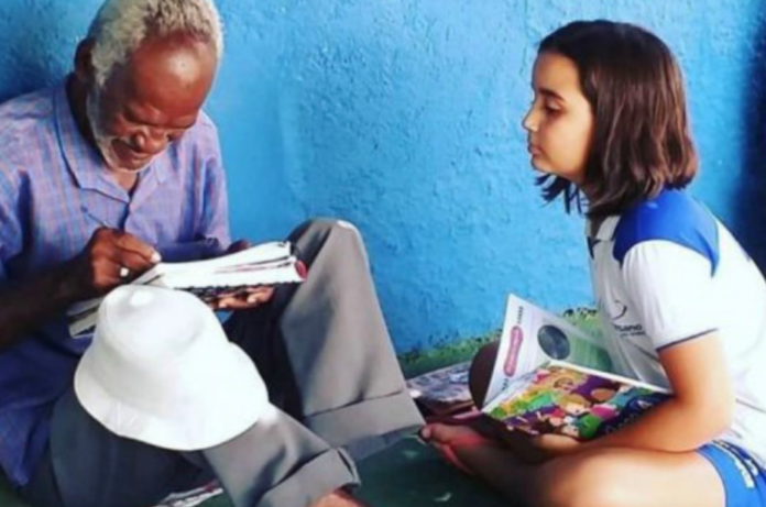 Una niña enseña a leer y escribir a un hombre analfabeto de 69 años